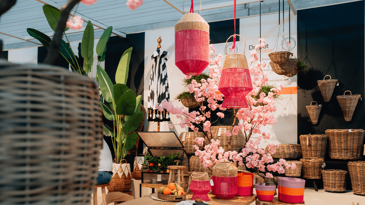 spoga+gafa 2026 Tag 3 12 Eine lebendige Ausstellung von hängenden Laternen, rosa Kirschblüten und Korbwickern in einem stilvollen Innenraum.